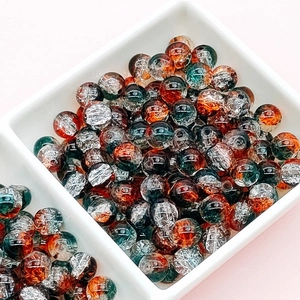 Macro shot of colorful crackle glass beads in a white bowl for DIY jewelry making