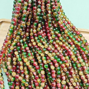 Detailed macro view of red, green, and yellow crackle glass beads for DIY jewelry making