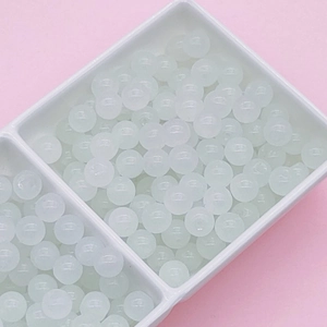 Macro view of translucent light green glass crackle beads for DIY jewelry making