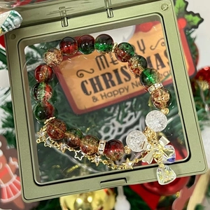 Detail of Christmas beaded bracelet with red and green glass beads in a green gift box