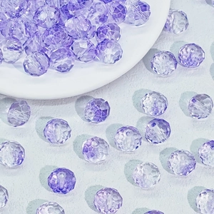 Dettaglio macro di perle di vetro sfaccettate viola sfumato per la creazione di gioielli