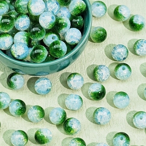 Close-up of green and white ice-cracked glass beads in a bowl for DIY jewelry making