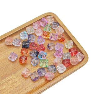 Handmade lion dance glass beads in colorful resin displayed on a natural wooden tray