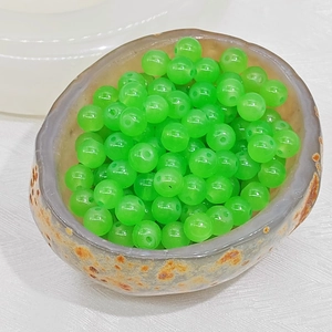Close-up of translucent bright green round beads with pre-drilled holes for DIY jewelry