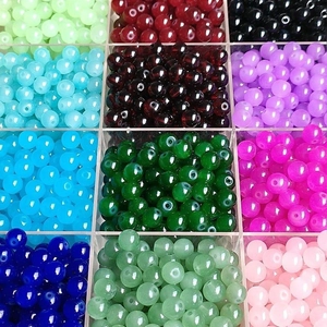 Multi-colored translucent glass round beads set in a storage box for DIY jewelry making