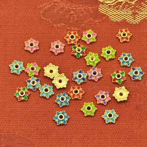 Macro shot of colorful enamel flower spacers for DIY jewelry making crafts