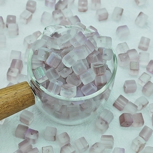 Vue macro de perles carrées en verre dépoli violet 7mm pour création de bijoux
