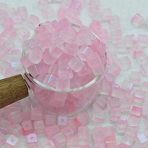 Détail macro de perles cubes en verre dépoli rose 7 mm pour bijoux et loisirs créatifs