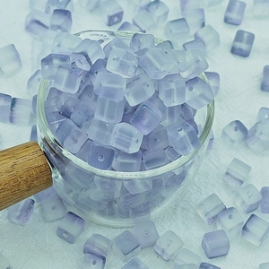 Gros plan sur des perles cubiques en verre dépoli violet de 7mm pour bijoux