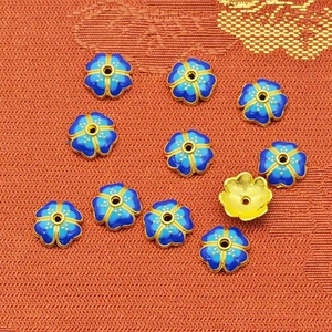 Macro shot of royal blue enamel flower bead spacers with gold finish for DIY jewelry making