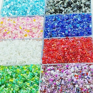Macro view of assorted glass seed beads in an 8-compartment organizer for DIY jewelry