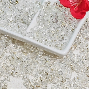 Macro shot of 6x12mm transparent bamboo tube beads with gold silk wire inserts for DIY jewelry