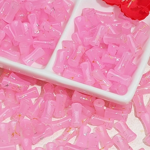 Macro shot of 12x6mm pink bamboo-shaped glass beads with gold foil for DIY jewelry