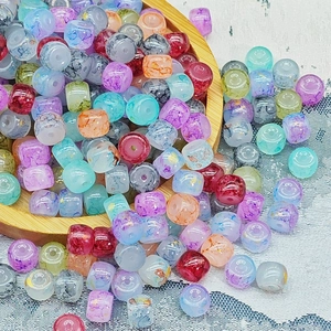 Dettaglio macro di perle di vetro colorate traslucide con foglia d'oro e marmo per il fai-da-te