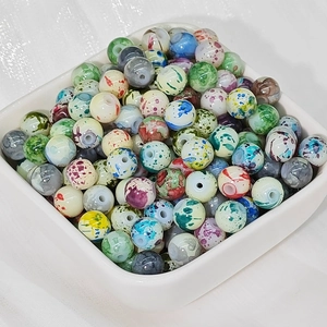 Perline di ceramica dipinte a inchiostro colorato per gioielli fai-da-te in una ciotola