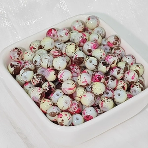 Dettaglio di perline in ceramica 8mm con motivi a schizzi d'inchiostro rosa e marroni