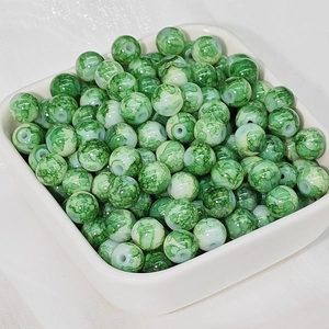 Dettaglio macro di perline in ceramica verde effetto marmo con fori per gioielli fai da te