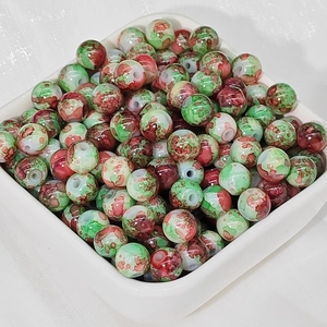 Dettaglio di perle in ceramica dipinte in rosso e verde per gioielli fai da te