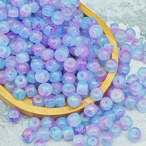 Dettaglio di perline cilindriche blu-viola con foglia d'oro in un vassoio di legno