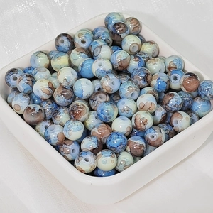 Dettaglio di perle in ceramica rotonde da 8mm con trama marmorizzata blu per gioielli fai da te
