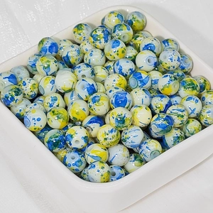 Dettaglio di perle in ceramica da 8mm con motivi a inchiostro blu e giallo in ciotola