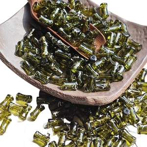 Bamboo-style olive green glass beads with white and gold brushed patterns on a tray