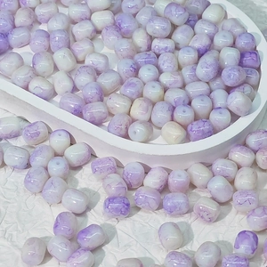 Dettaglio di perle ovali in resina bianca con venature viola per la creazione di gioielli