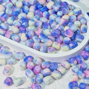 Dettaglio macro di perle in ceramica da 8mm a botte con trama marmorizzata blu e viola