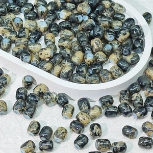 Dettaglio di perline cilindriche dipinte con trama in pietra naturale per gioielli fai-da-te