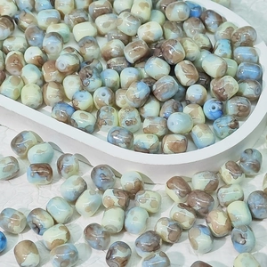 Dettaglio macro di perle in ceramica marmorizzata con smalto naturale per gioielli DIY