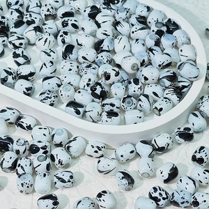 Vue détaillée des perles en porcelaine blanche avec motif marbre noir pour bijoux DIY