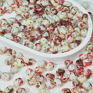 Vue macro de perles ovales style porcelaine avec texture lavis brun pour bijoux DIY