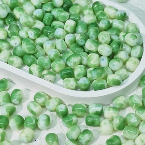 Vue macro de perles en porcelaine marbrée verte et blanche pour création de bijoux DIY
