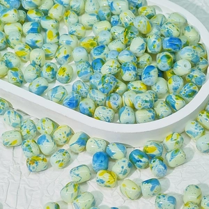 Vue macro de perles en céramique peintes à la main avec taches bleues et jaunes pour bijoux DIY