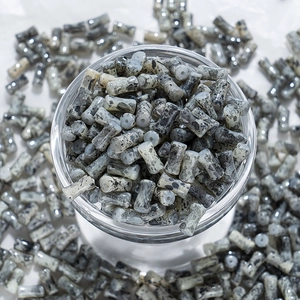 Détail macro de perles en céramique cylindriques peintes à l'encre pour bijoux DIY