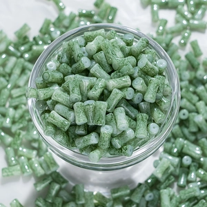 Détail macro de perles colonnes vert clair avec texture marbrée pour création de bijoux