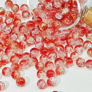 Dettaglio di perle in vetro craquelé rosso e bianco con fili d'oro per gioielli fai-da-te