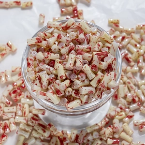 Détail macro de perles en porcelaine cylindriques avec taches d'encre rouge pour bijoux