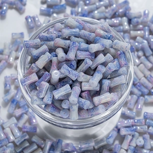 Vue macro de perles en céramique à effet d'encre bleu et blanc pour création de bijoux