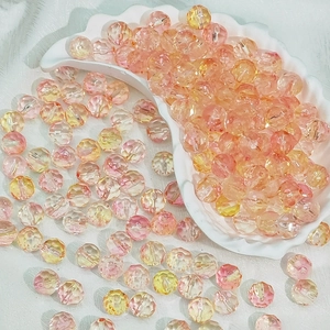 Macro detail of faceted pink and yellow gradient acrylic beads for DIY jewelry making