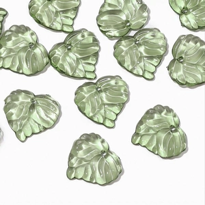 Macro detail of translucent green acrylic leaf beads with delicate veins for jewelry making