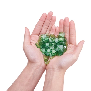 Macro shot of mini translucent green acrylic leaf beads with realistic vein textures