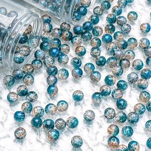 Detail of 10mm cracked blue glass beads spilling from bottles for DIY jewelry making
