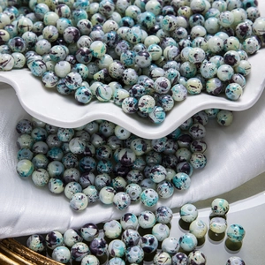 Vue macro de perles en céramique peinte verte avec marbrures pour bijoux artisanaux