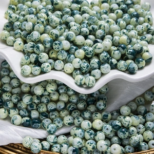 Gros plan de perles en céramique peintes à l'encre verte avec textures tachetées