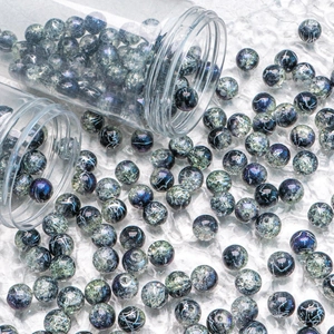Macro detail of 10mm cracked blue glass beads for DIY jewelry making in clear tube