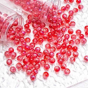 Detail of 10mm red cracked glass beads being poured from transparent storage tubes