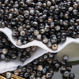 Gros plan de perles rondes mouchetées noires et blanches pour la création de bijoux DIY
