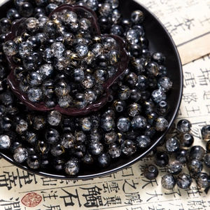 Macro detail of 10mm black and gold cracked glass beads for DIY jewelry making