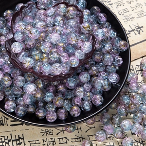 Detailed macro view of 10mm purple and blue ice-cracked glass beads with gold leaf patterns